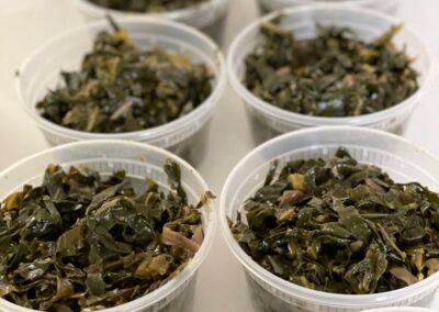 Greens in plastic containers on a table in an Ethiopian Flavors cooking class