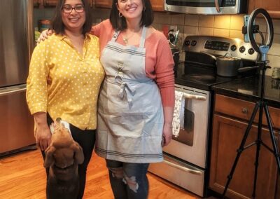 two women and a dog in the kitchen