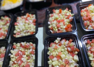 Chopped vegetables in black trays.