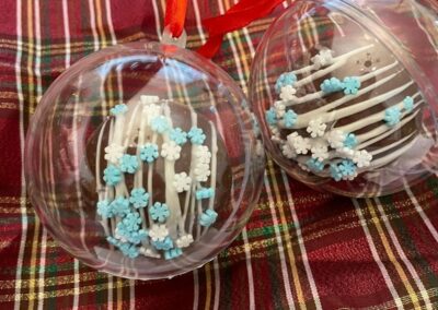 Two ornaments with blue and white snowflakes on them.