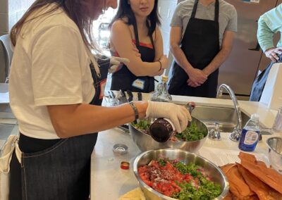 A group of people preparing Lebanese food in a kitchen during the Lebanese Cooking Class with Jihan.