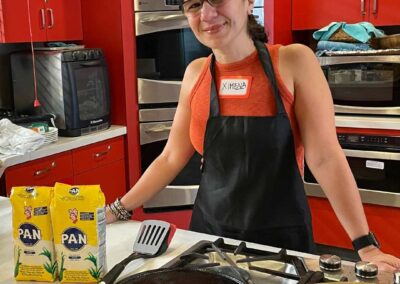 Ximena in an apron standing in a kitchen during her Venezuelan Cuisine cooking class