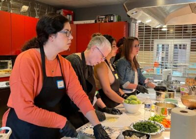 A group of people preparing food in a kitchen during the Venezuelan Cuisine Cooking Class