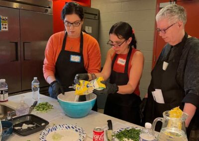 Three people in aprons preparing Venezuelan Cuisine in a cooking class