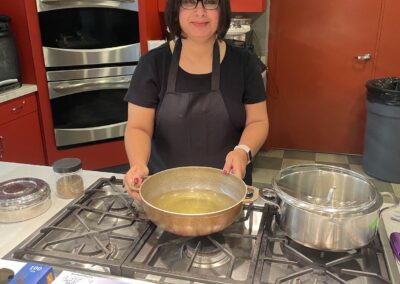 Chef Babita standing in a kitchen leading the Everyday Indian Recipes cooking class