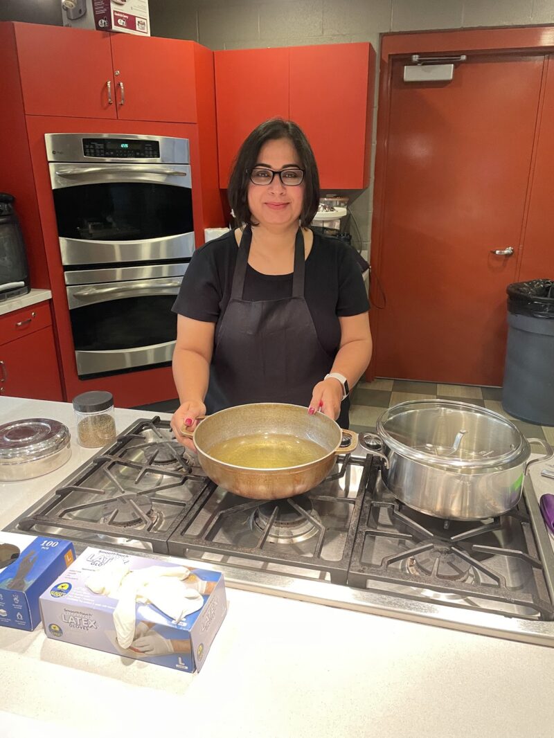 Chef Babita standing in a kitchen leading the Everyday Indian Recipes cooking class