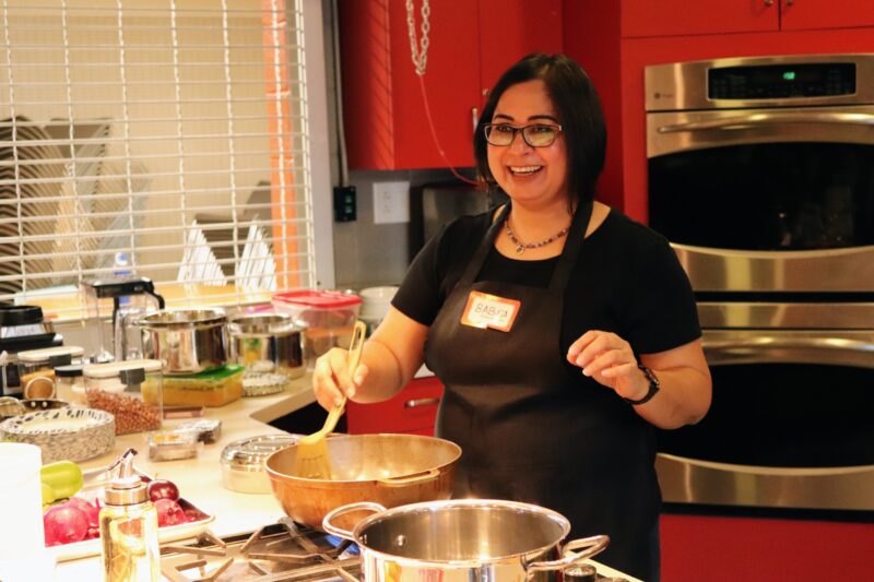 Chef Babita wearing an apron and leading a cooking class