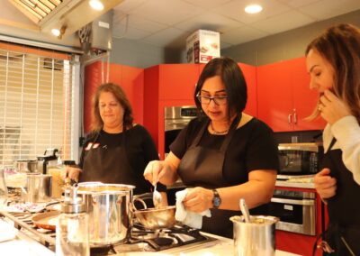 Three women in Aprons in a South Indian Cooking Class
